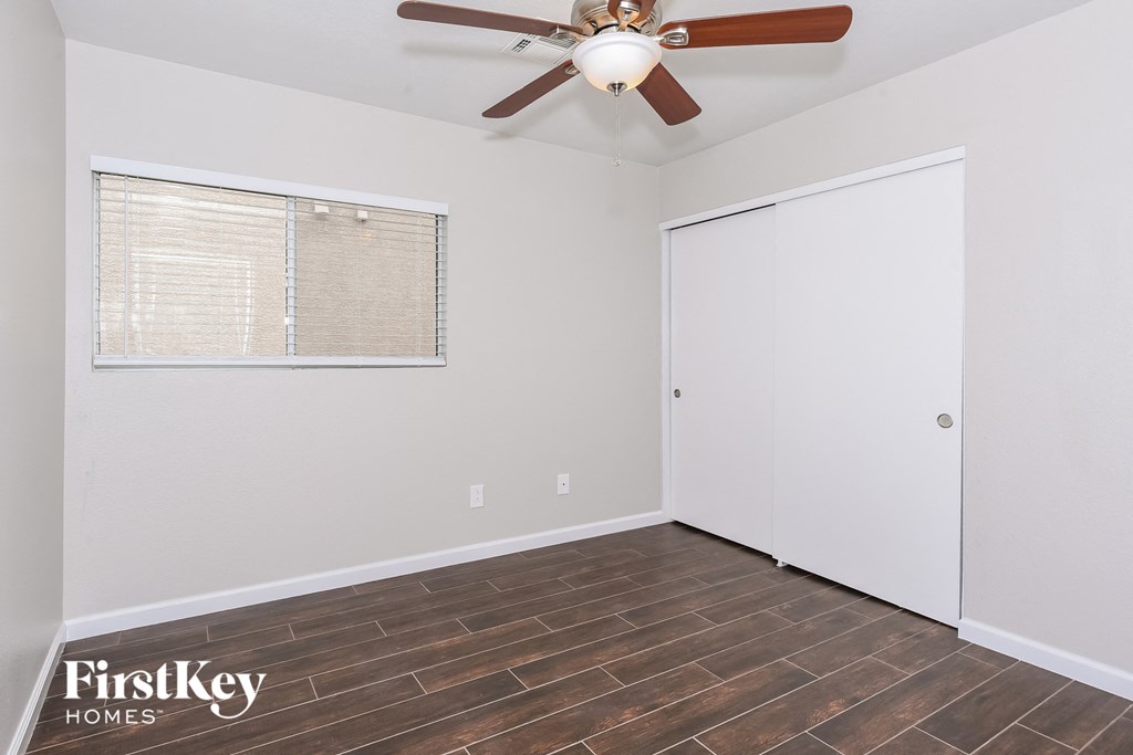 a bedroom with a ceiling fan and a closet