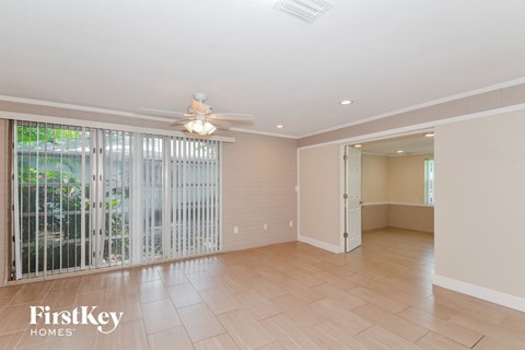 A spacious room with a sliding glass door leading to a balcony.