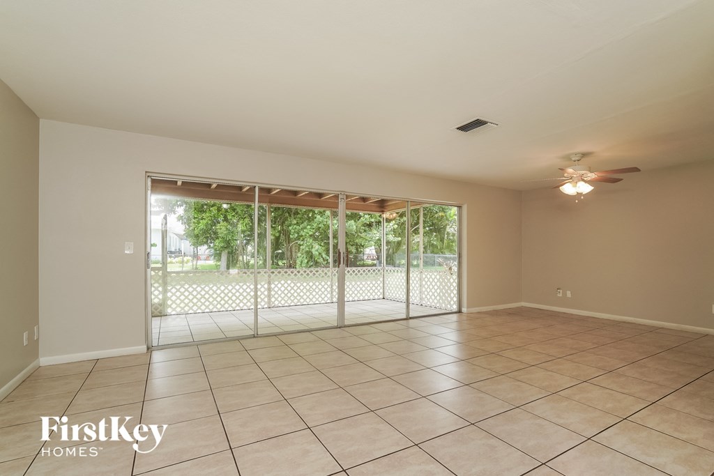 A spacious room with a sliding glass door leading to a backyard.