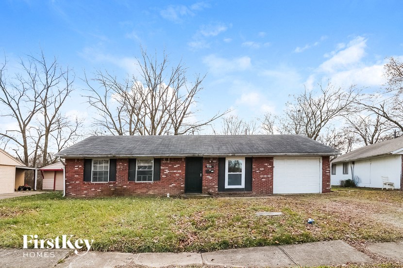 the front of a brick house with a grassy yard