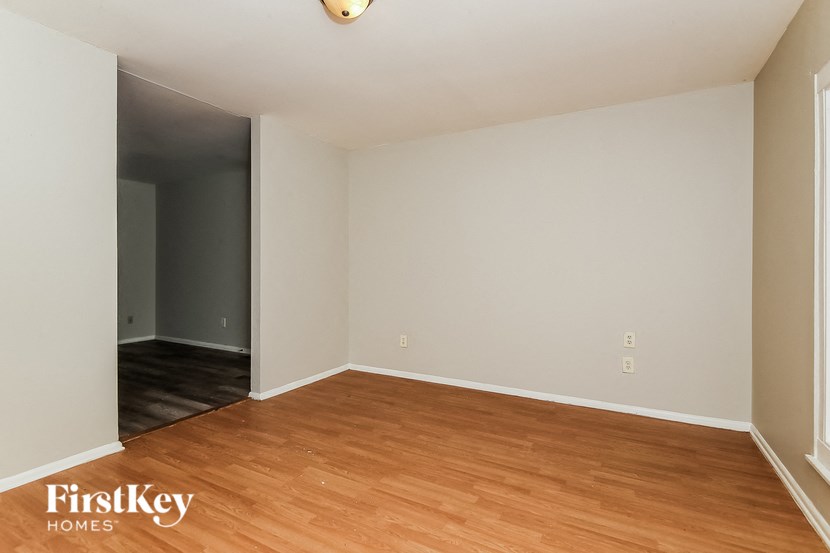 an empty living room with wood flooring and white walls
