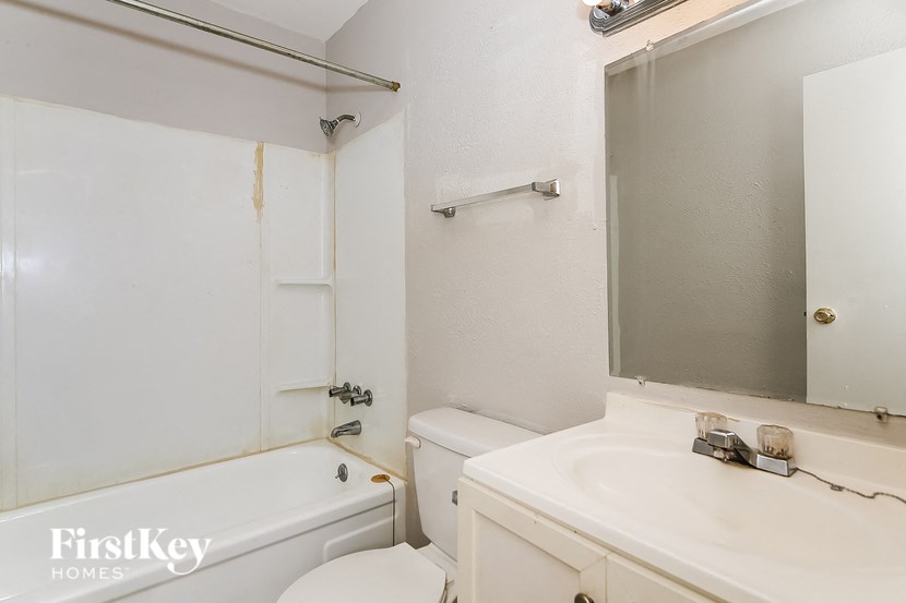 a bathroom with a sink toilet and tub and a mirror