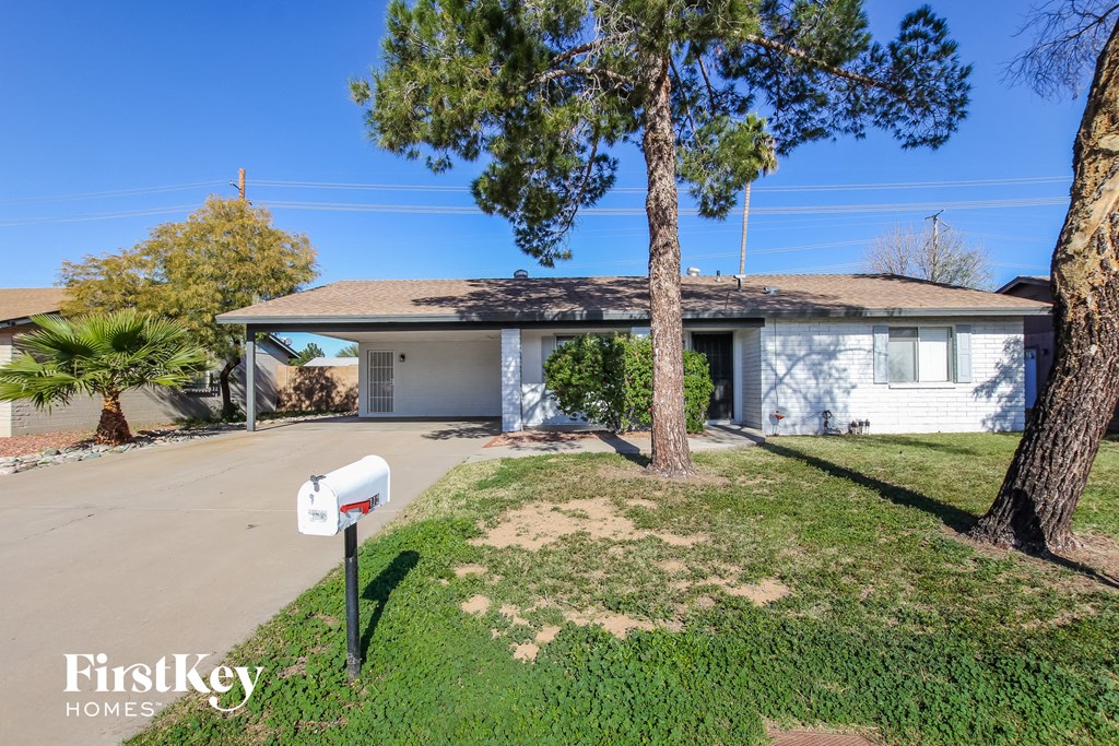 a white house with a mailbox on the side of the road