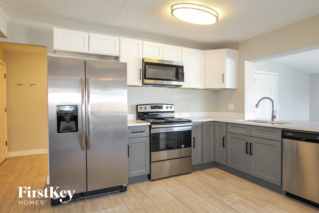 a kitchen with stainless steel appliances and white cabinets