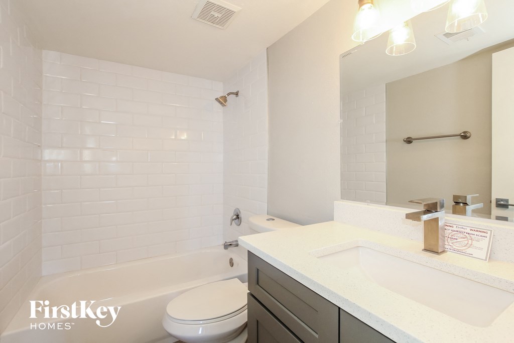 a white bathroom with a tub and a sink and a toilet