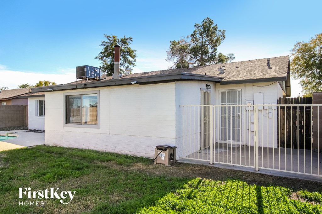 a small white house with a fence and a gate