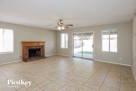 A spacious room with a fireplace and sliding glass doors.