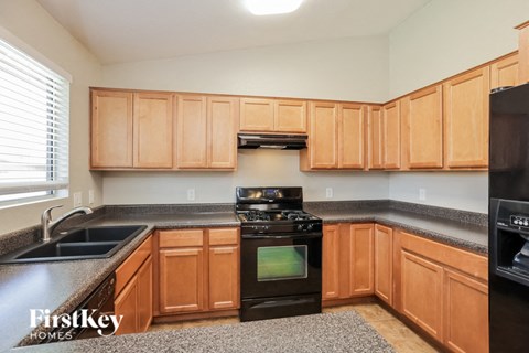 A kitchen with wooden cabinets and black appliances.
