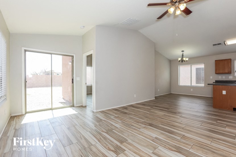 A spacious room with wooden flooring and a ceiling fan.