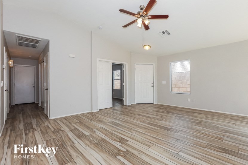 A spacious room with wooden flooring and a ceiling fan.