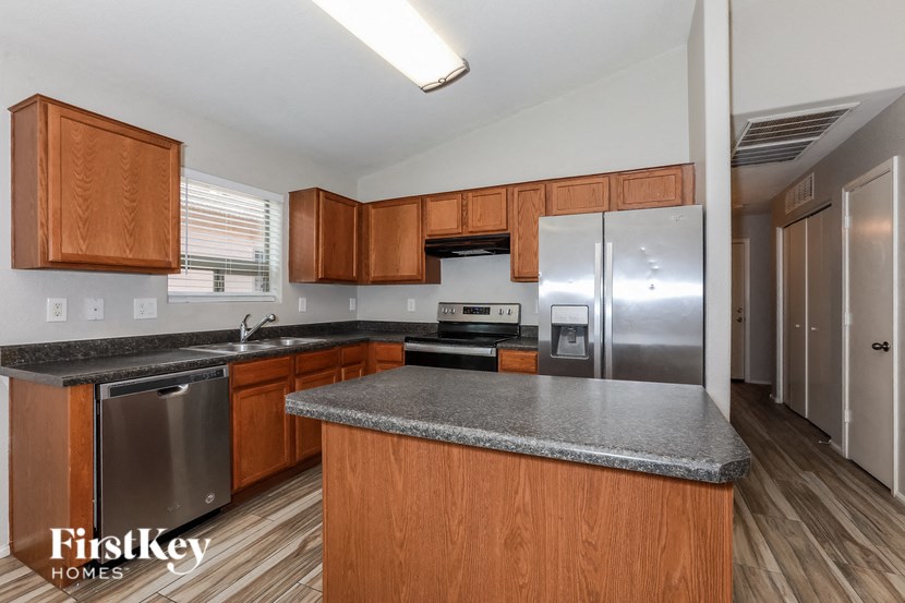 A kitchen with wooden cabinets and a granite countertop.
