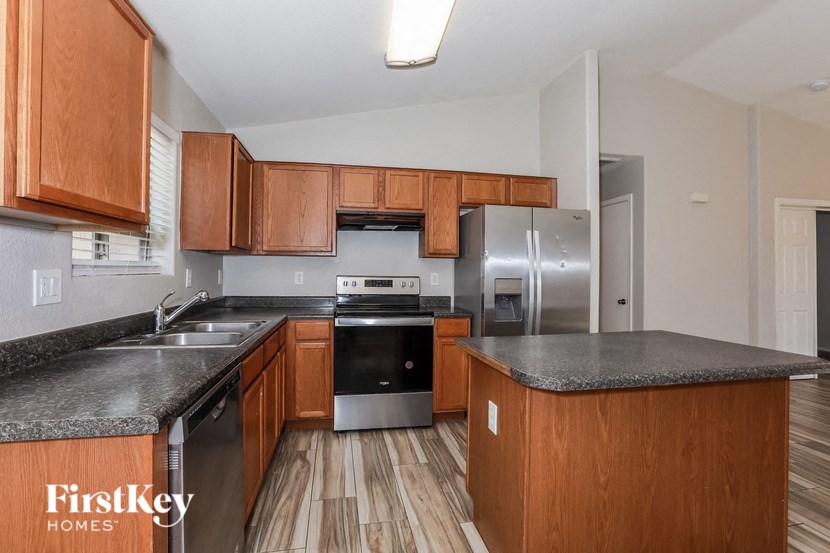 A kitchen with wooden cabinets and a granite countertop.