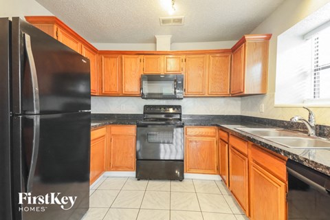 a kitchen with black appliances and wooden cabinets