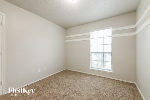 a bedroom with a window and carpeting
