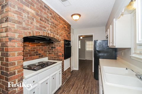 a kitchen with a brick wall and a stove and a sink