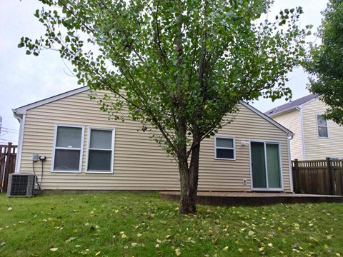 A small house with a tree in front of it.