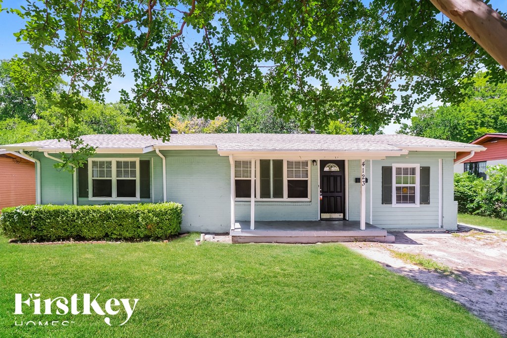 A house with a green front yard and a red roof is for sale.