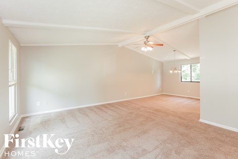 A spacious room with a ceiling fan and light fixture.
