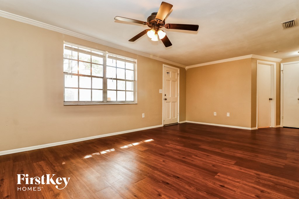 A room with wooden floors and a ceiling fan.
