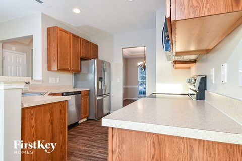 a kitchen with a white counter top and a stainless steel refrigerator