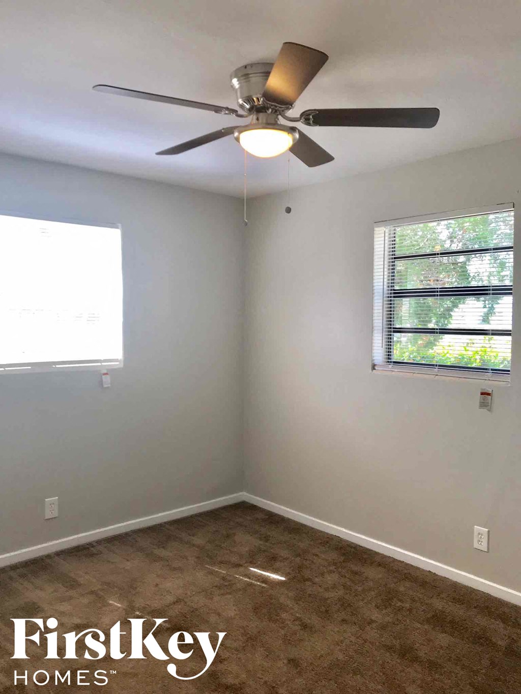 a white room with a ceiling fan and a window