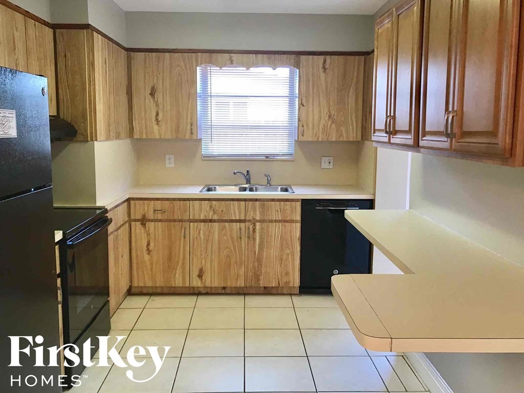 a small kitchen with wooden cabinets and a sink