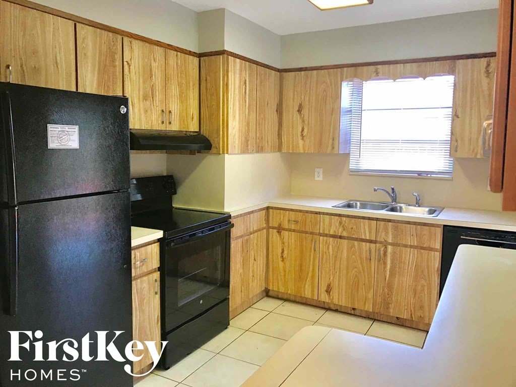 a kitchen with black appliances and wooden cabinets