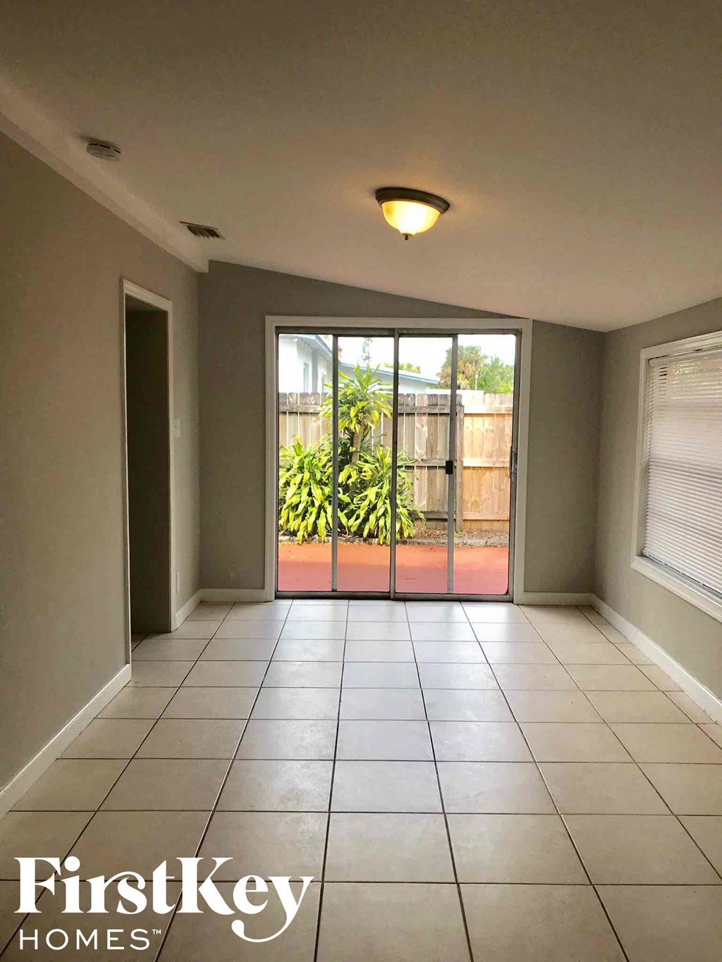 an empty living room with a sliding glass door to a patio