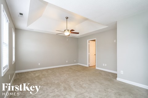 a living room with carpet and a ceiling fan
