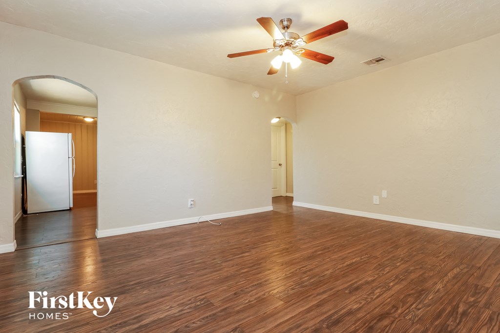 the living room and dining room with hardwood flooring and a ceiling fan