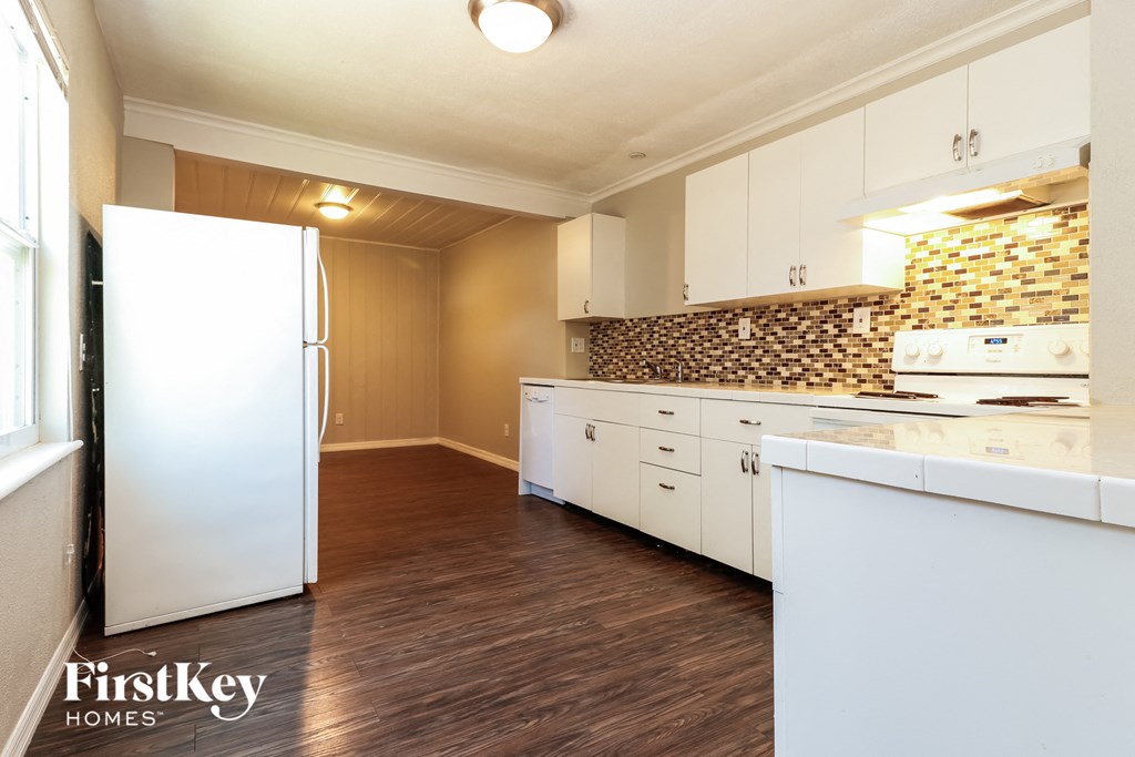 a kitchen with white cabinets and a white refrigerator