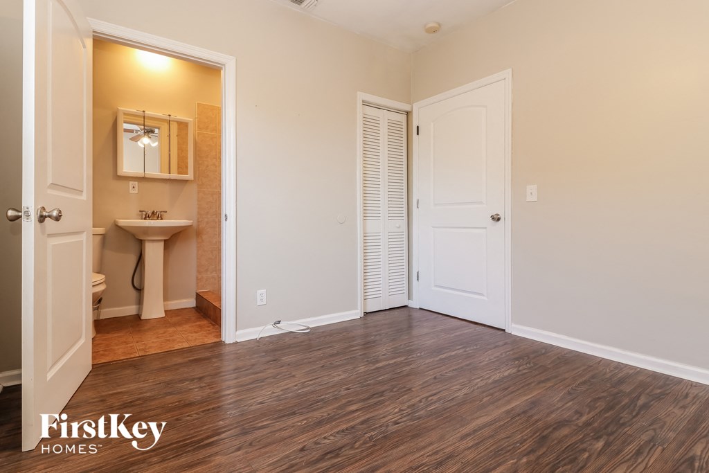 an empty living room with a door to a bathroom