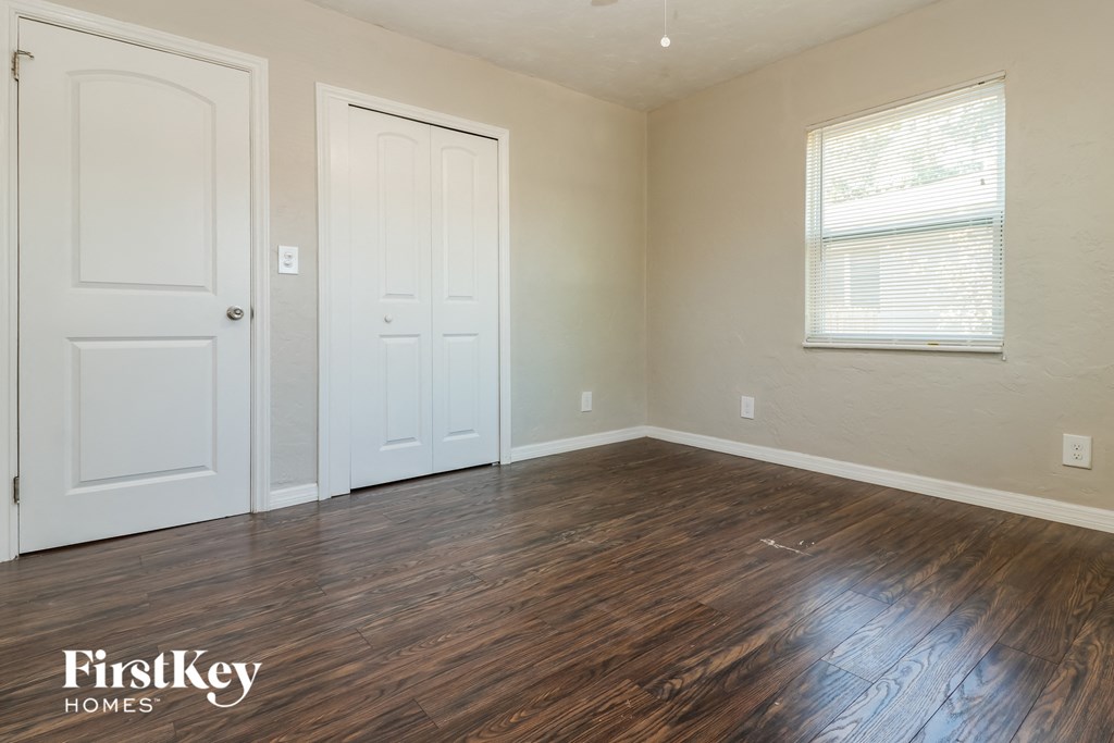 the living room of a home with wooden floors and white doors