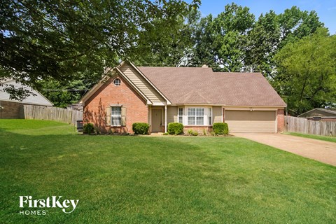A house with a brown roof and a white fence.