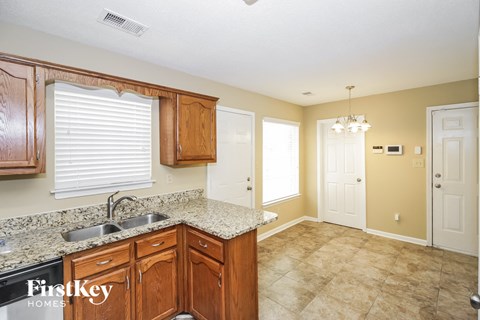A kitchen with wooden cabinets and a granite countertop.