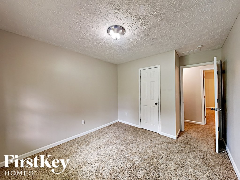 a bedroom with carpet and a door to a closet