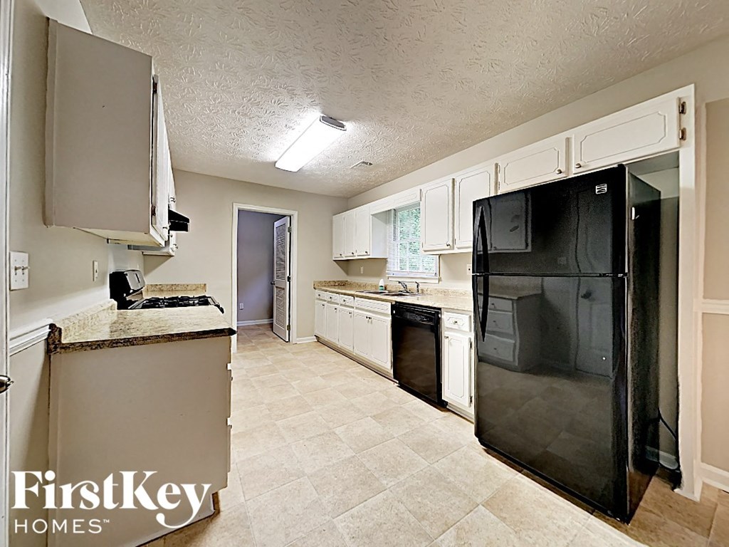 a kitchen with black appliances and white cabinets