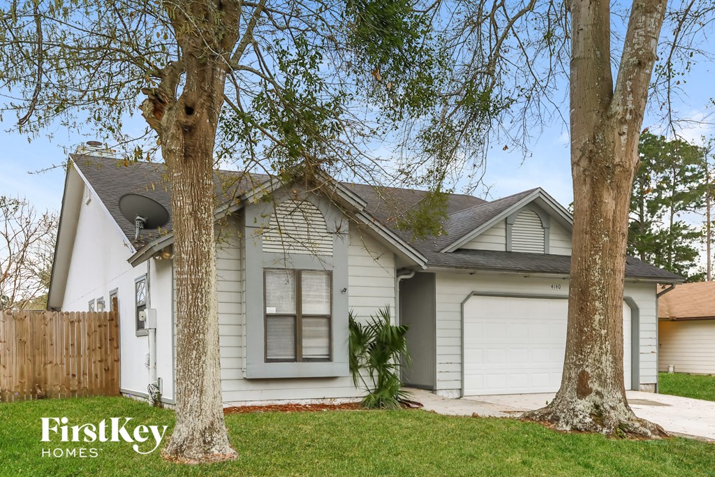 a white house with two trees in front of it