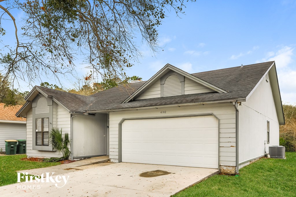 the front of a white garage with a white house
