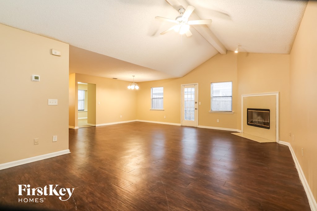 the living room and dining room of an empty house with a fireplace
