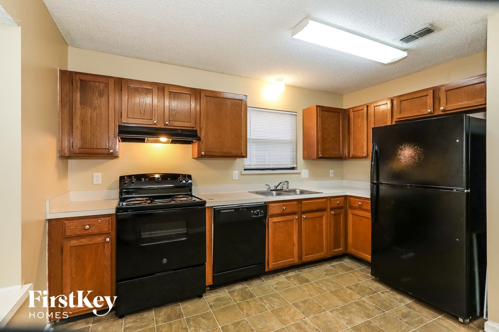 a kitchen with black appliances and wooden cabinets