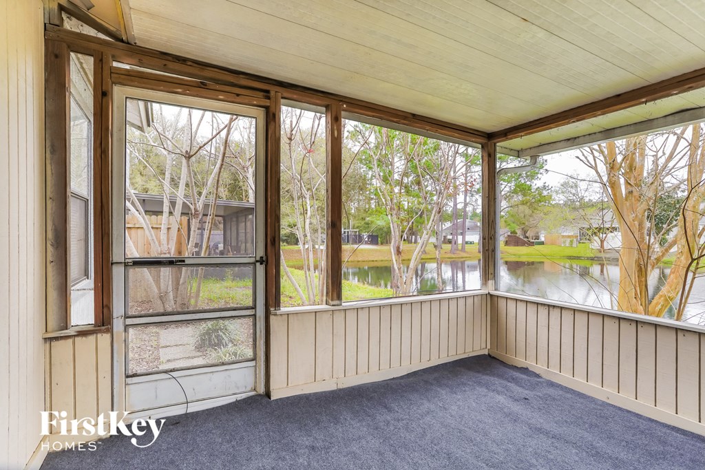a screened porch with a view of the water