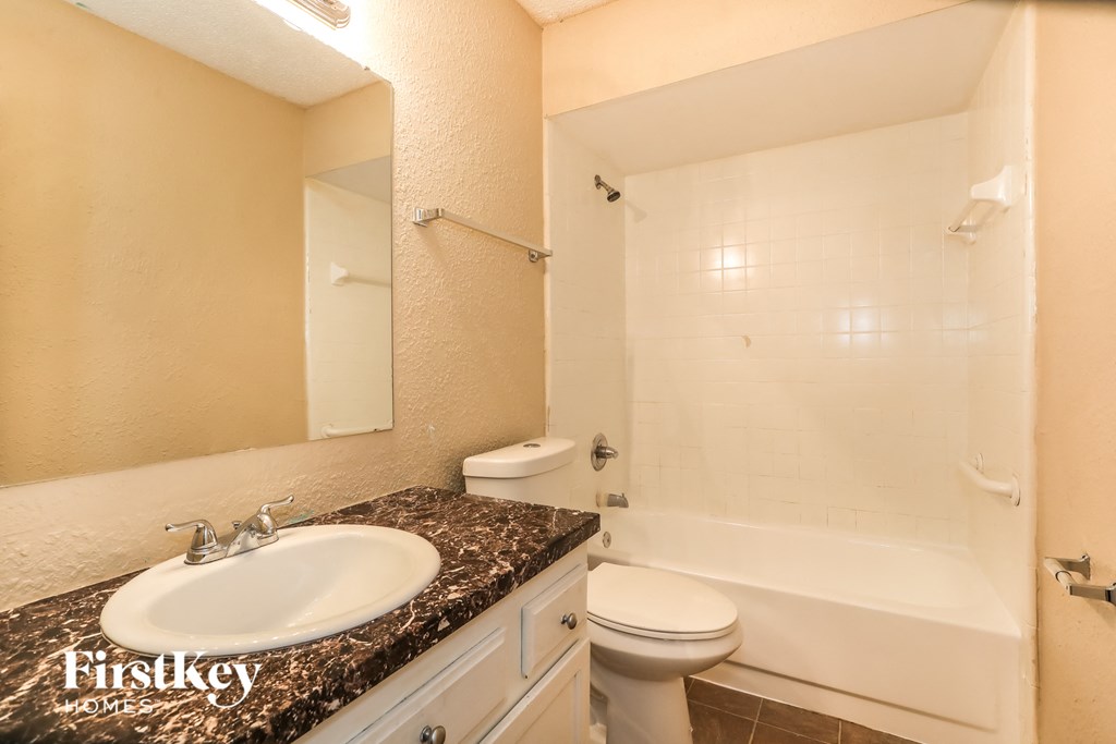 a bathroom with a sink and a toilet and a bath tub