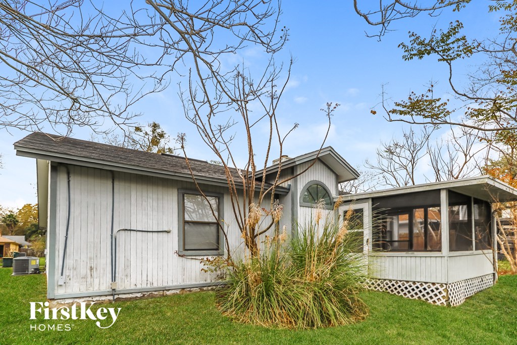 the exterior of a white house with a green roof
