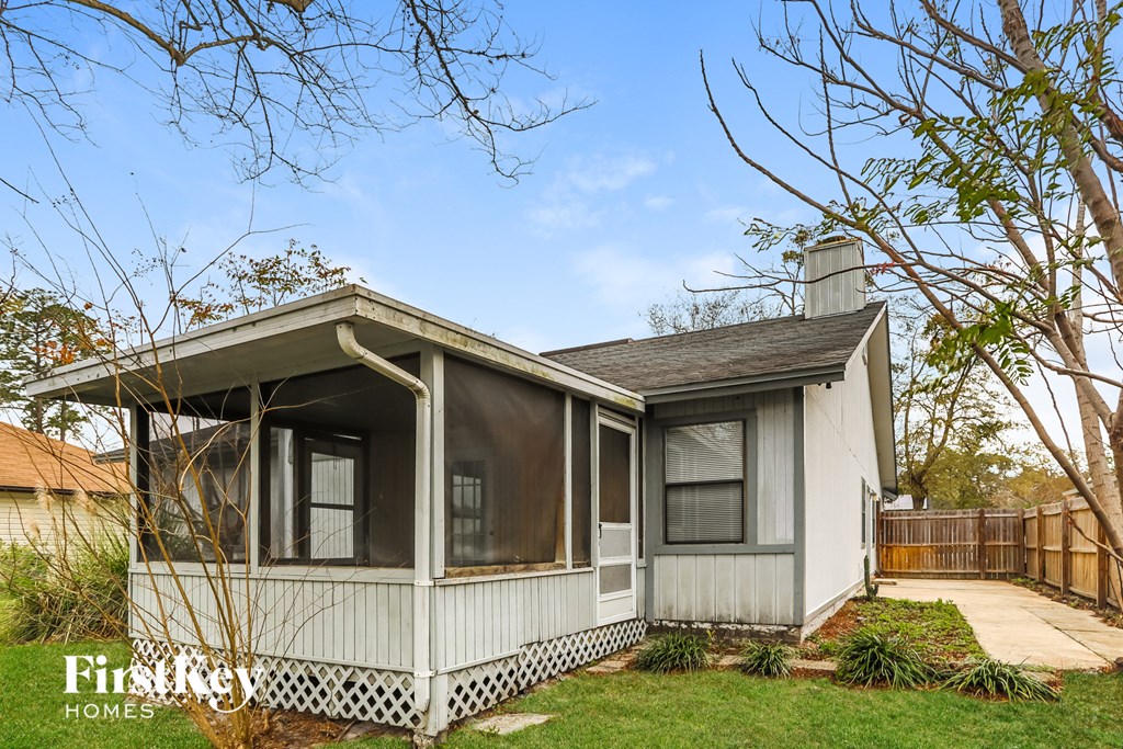 a small white house with a porch and a fence