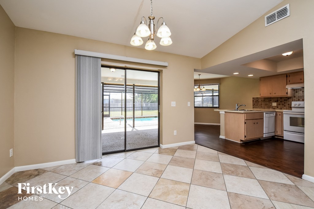 an open kitchen and living room with sliding glass doors to the pool