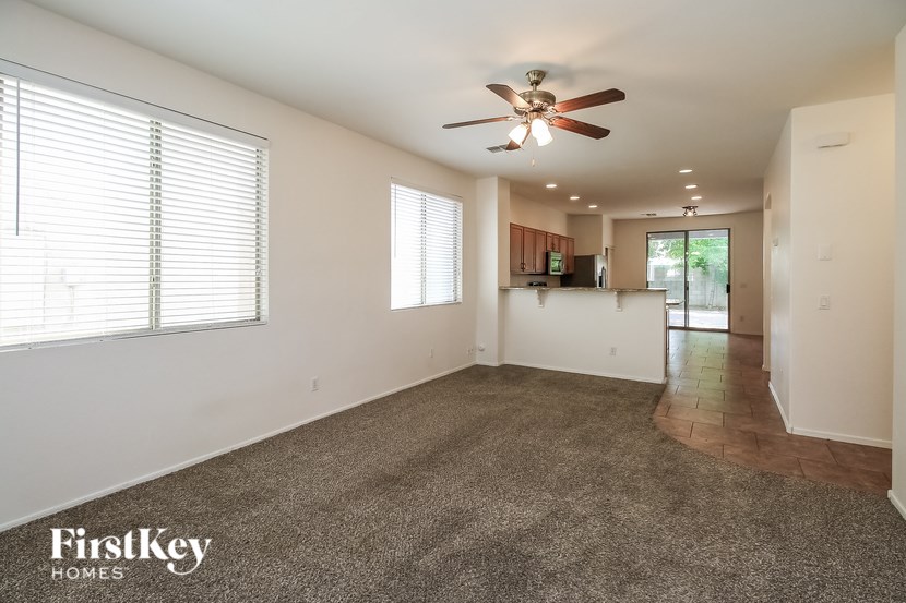 A spacious room with a ceiling fan and carpeted floor.