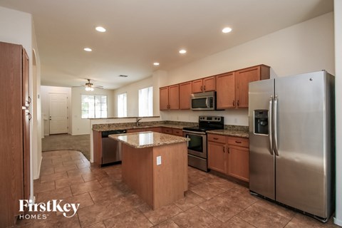 A kitchen with a refrigerator, microwave, and oven.