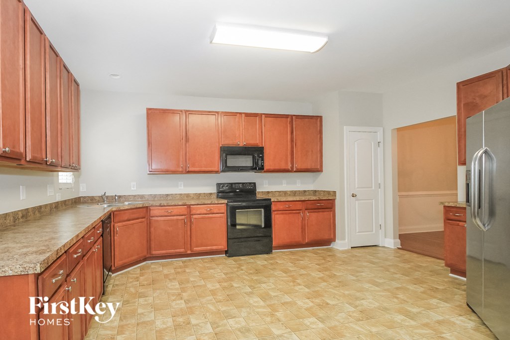 a kitchen with wooden cabinets and a counter top and a black stove