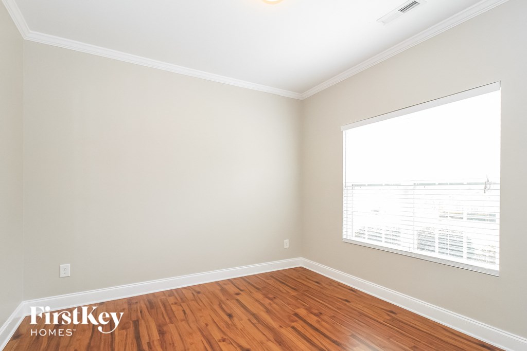an empty room with wood floors and a large window